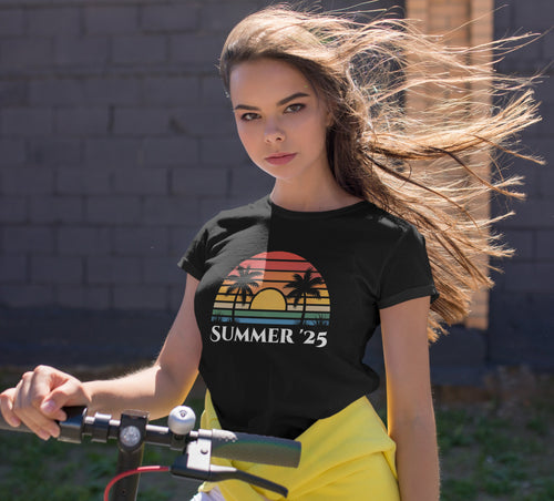 Woman with long hair holding a bicycle, wearing a black t-shirt with 'Summer '25' design.